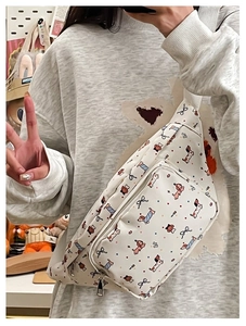 Detail of white crossbody bag with cute dog and bow pattern on a female model