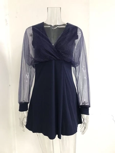 Detail of V-neck wrap dress with sheer mesh sleeves and silver sequins on navy blue fabric