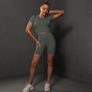 Detail of seamless olive green yoga set featuring high-waist shorts and short-sleeve crop top