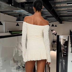 Macro view of textured 3D fabric and ruffled hem on an off-shoulder bodycon mini dress
