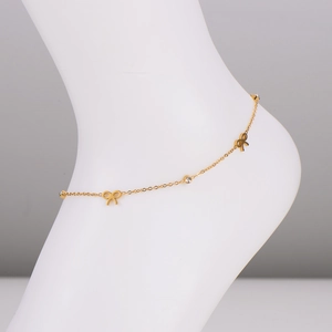 Elegant gold anklet with delicate bows and rhinestones shown on a model's ankle