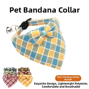 Detail of adjustable plaid pet collar with breakaway safety buckle and bell accessory