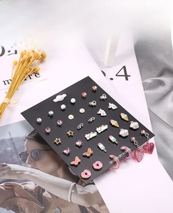 Detailed view of colorful enamel lollipop and donut earring set with various cute motifs