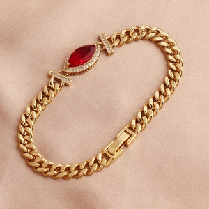 Elegant gold plated copper bracelet with red marquise zircon on pink silk backdrop