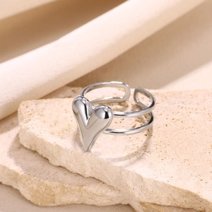 Close-up of a silver heart-shaped double-layered open ring on a stone