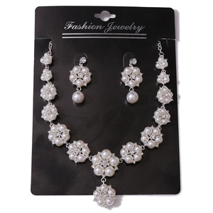 Elegant gold-tone wedding jewelry set featuring white pearls and sparkling rhinestones