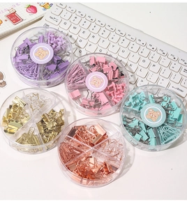 Macro detail of macaron colored stationery set with clips and pins in round storage boxes