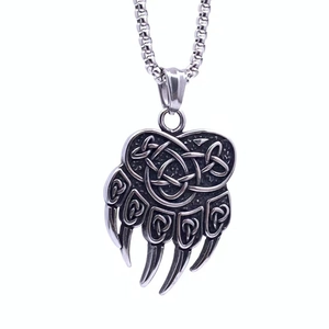 Macro shot of Viking bear claw pendant featuring intricate Celtic knot engravings in silver