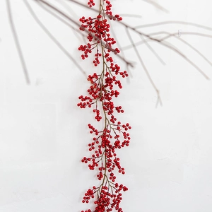 Deluxe artificial red berry garland for Christmas home decoration hanging on white wall