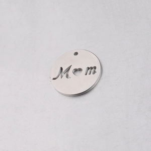 Macro detail of 20mm round stainless steel cutout Mom pendant with heart shaped center