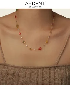 Détail du collier élégant avec pierres précieuses colorées et mini perles sur le cou