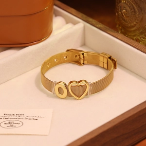 Détail du bracelet en maille dorée avec breloques cœur et zéro dans un écrin à bijoux
