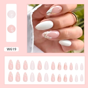 Detail view of almond shape floral press-on nails with white leaf and gold French tip designs