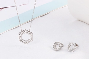 Detailed view of silver hexagonal necklace and stud earrings set with sparkling crystals
