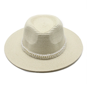 Détail d'un chapeau de paille crème avec ruban de perles élégant et large bord plat