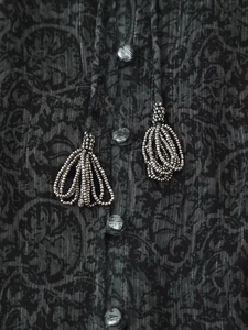 Detail von V-Ausschnitt Kleid mit Paisley-Muster, Silberstreifen und Perlenquastenfransen