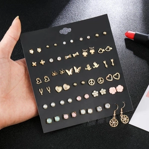 Close-up of heart and flower stud earring set with zircons on a black display card