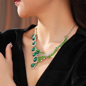 Close-up of vintage silver necklace with green teardrop crystal and rhinestone pendant