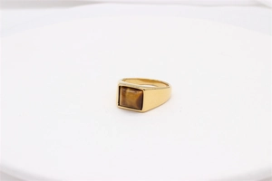 Macro shot of men's titanium steel gold ring featuring a square tiger eye gemstone