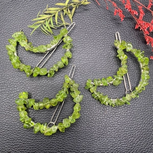 Detailed view of crescent moon hair clips featuring natural green crystal stone inlay