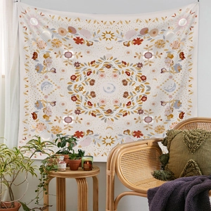 Detail of bohemian tapestry featuring sun and moon patterns in earthy tones for wall decor