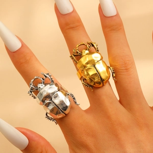 Macro shot of detailed gold and silver beetle insect rings worn on fingers