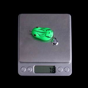 Green frog lure with metal spinning blades weighing 7.8g on a digital scale