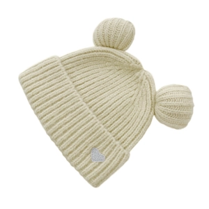 Detail of off-white knit hat with bear ear pom-poms and a sparkling heart patch