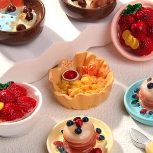 Macro detail of miniature resin dessert models including strawberry ice cream and muffins
