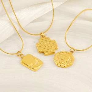 Three-piece gold layered necklace featuring coin, cross and rectangular relief pendants