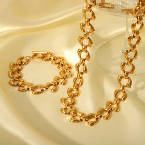 Elegant gold-plated horseshoe link chain jewelry set on champagne silk fabric background