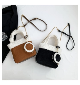 Detail of brown and black suede bucket bags with faux shearling trim and chain strap