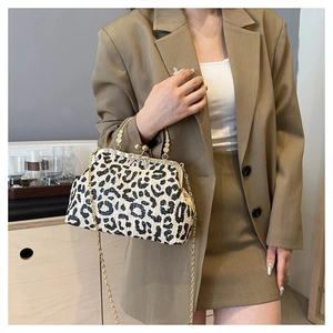 Detail of leopard print woven clutch bag with gold bead handle and chain shoulder strap