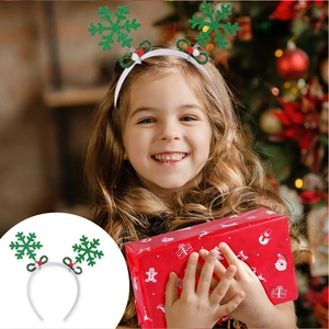 Detail of Christmas headband with green glitter snowflakes worn by a girl at a party