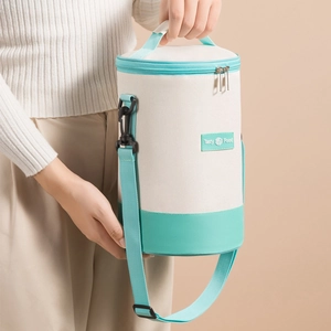 Insulated cylindrical lunch bag in cream canvas with mint green straps and Tasty Food label