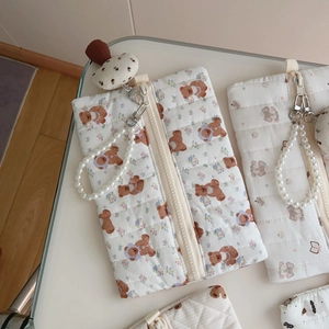 Detail of quilted bear handbag with pearl handle and mushroom plush charm detail