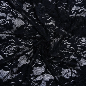 Close-up of black lace fabric showing intricate floral patterns and mesh texture on skirt