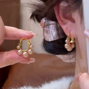 Detail of 18K gold plated hoop earrings featuring champagne pearls and cubic zirconia stones