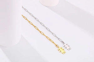 Détail de bracelets chaîne trombone en or et argent avec pendentifs silhouette de fille