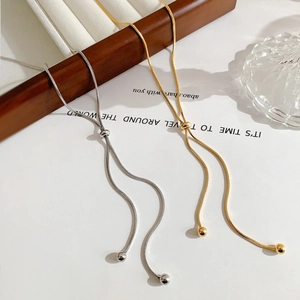 Detail of adjustable snake bone necklace with sliding bead and polished metal ends