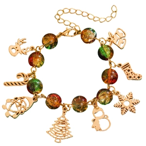 Close-up of golden Christmas charms including Santa, reindeer, and snowflakes on a beaded bracelet