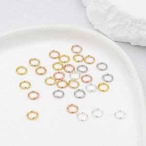 Macro detail of gold, silver, and rose gold jump rings for DIY jewelry making