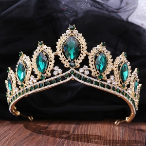 Detail of baroque gold crown with emerald green teardrop crystals and white rhinestones