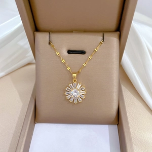 Close-up of golden sunflower pendant with zircon crystals in a beige jewelry box