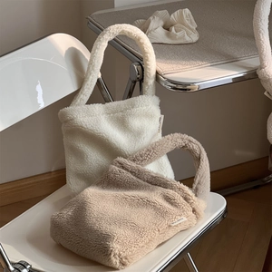 Winter faux shearling small tote bag in cream and khaki colors on a chair