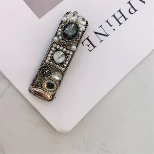 Detail of vintage hair clip with dark grey crystal, rhinestones and pearls on bronze base