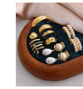 Detail of vintage 18K gold plated jewelry with pearls and zircon on blue velvet tray
