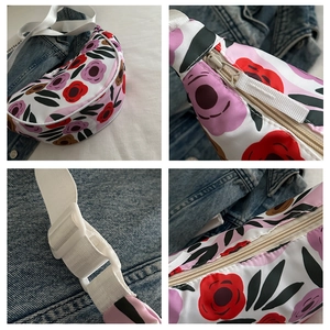 Detail view of floral dumpling bag showing zipper and adjustable white plastic buckle