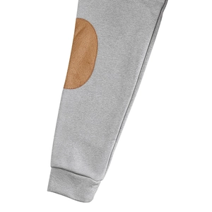 Dettaglio del polsino grigio con toppa marrone sul gomito che mostra texture e cuciture