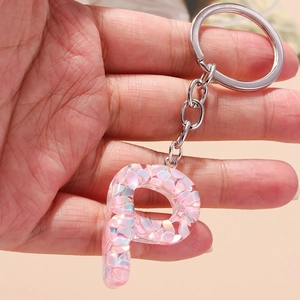 Detailed view of resin letter P keychain filled with pink iridescent sequins and silver ring